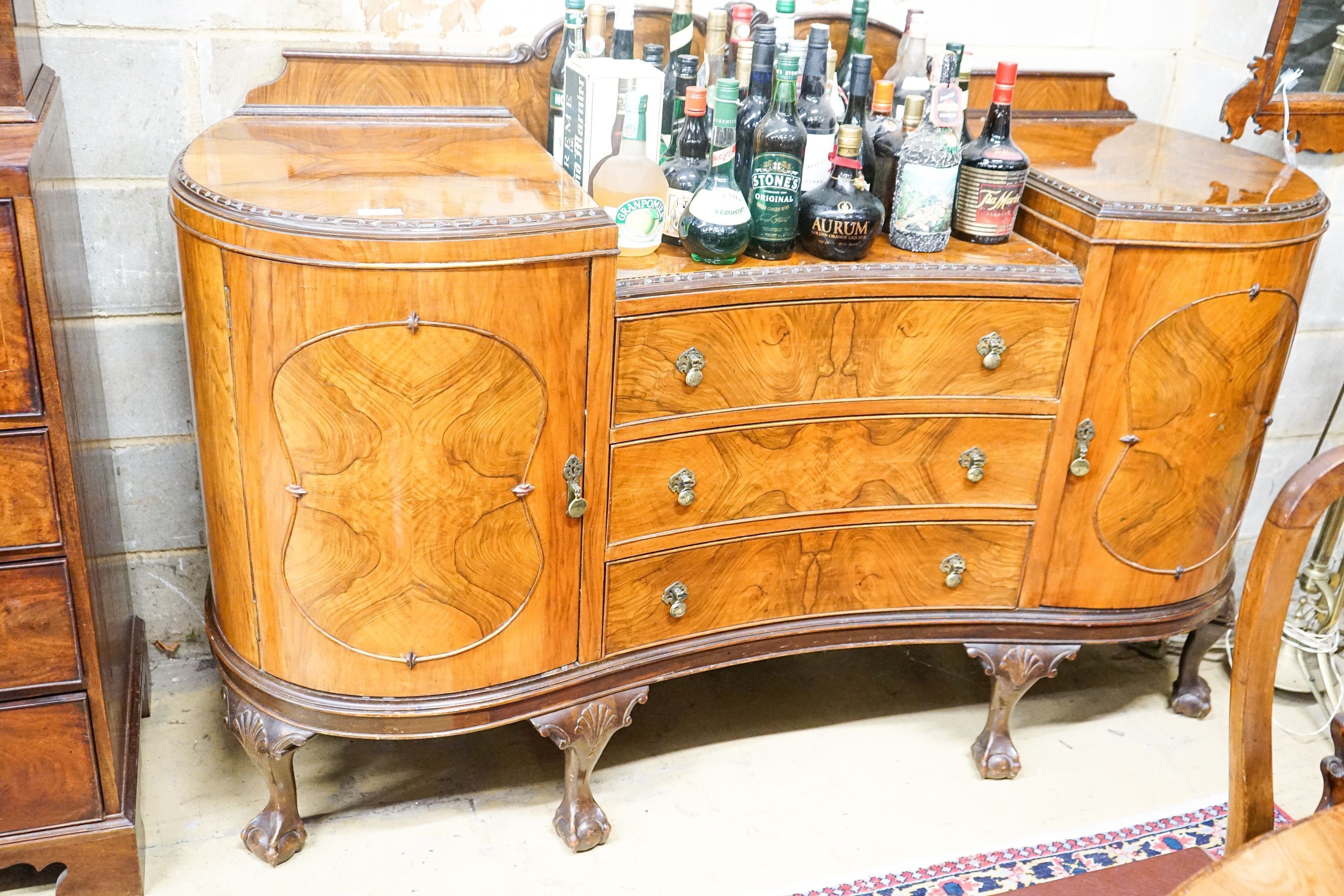 A Queen Anne style figured walnut dining suite comprising extending dining table, 200cm extended (one spare leaf), width 104cm, height 76cm, six chairs (two with arms) and a concave fronted sideboard